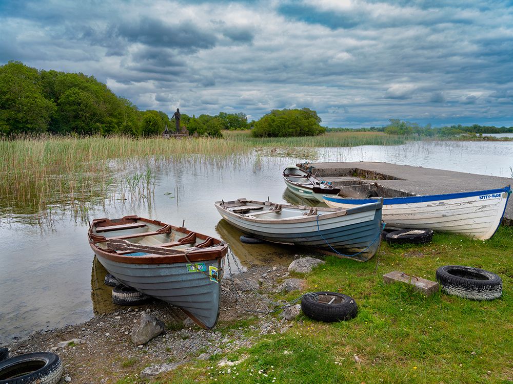 Boats await skippers on Lough Carra-County Mayo-Ireland. Shrine watches over the fishermen. art print by Betty Sederquist for $57.95 CAD