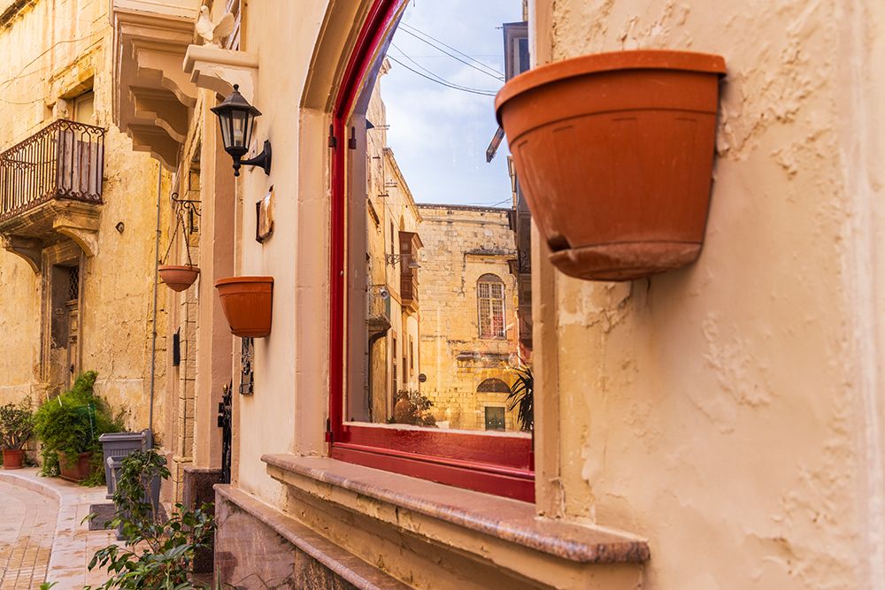 Malta, Birgu. Window reflection of narrow streets and stone buildings. art print by Emily M. Wilson for $57.95 CAD