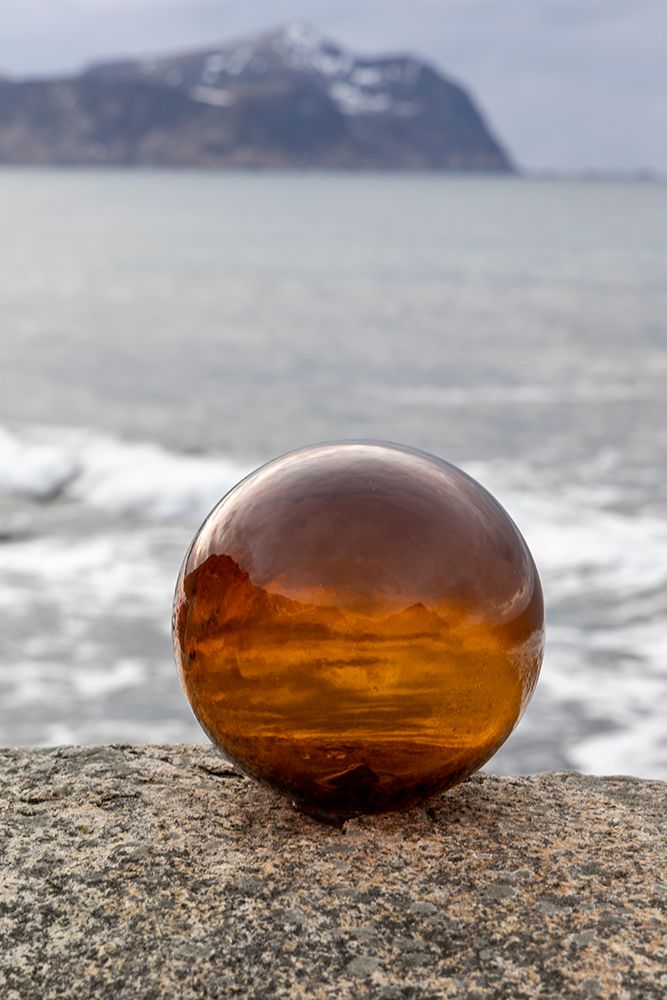 Norway- Lofoten Islands- Vareid. Mountains and ocean viewed through a glass ball art print by Hollice Looney for $57.95 CAD