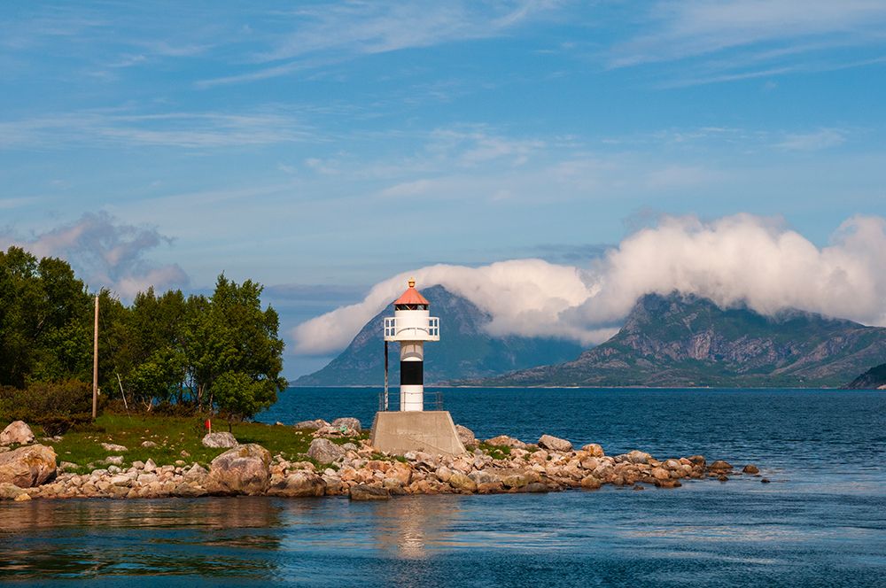 A lighthouse perches on a rocky promontory and reflects on Holandsfjorden Svartisen-Norway art print by Sergio Pitamitz for $57.95 CAD