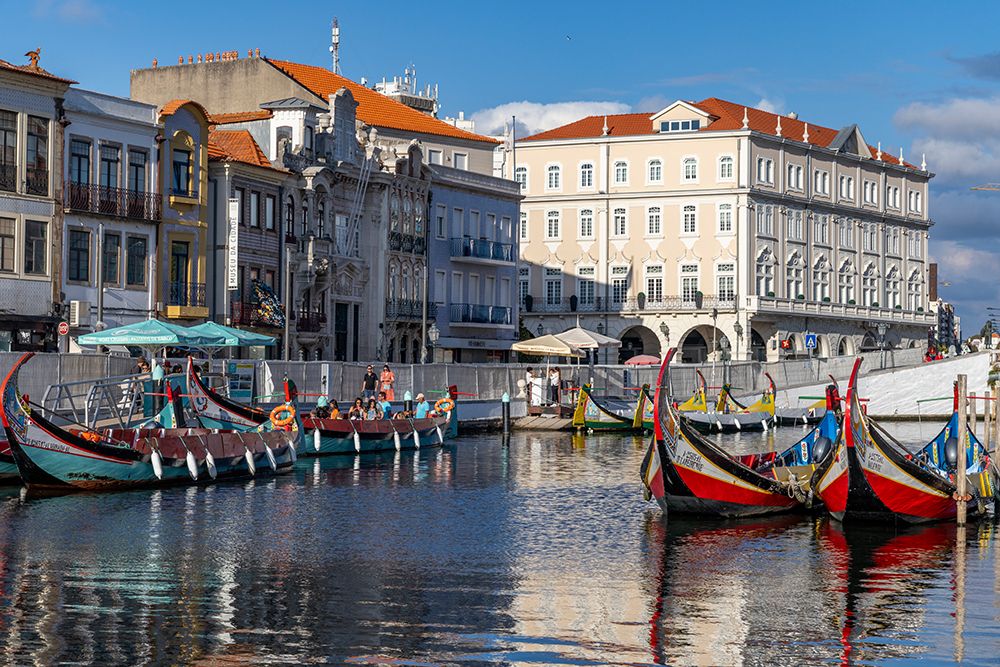 Gondola style fishing tour boats in canal in Aveiro, Portugal. art print by Chuck Haney for $57.95 CAD
