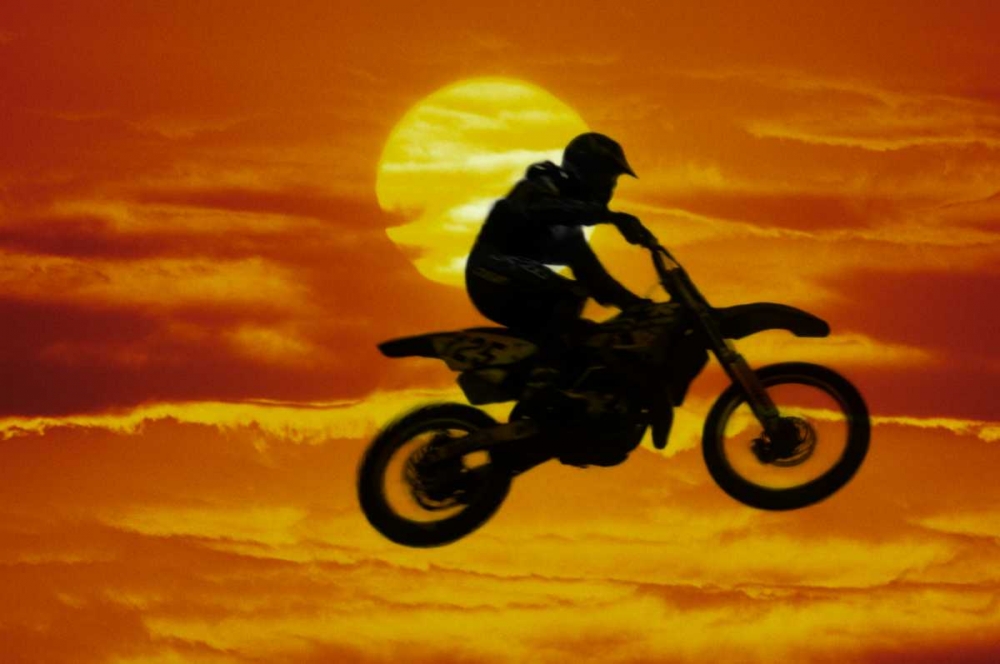 Motocross racer doing jump in front of big sun art print by Steve Satushek for $57.95 CAD