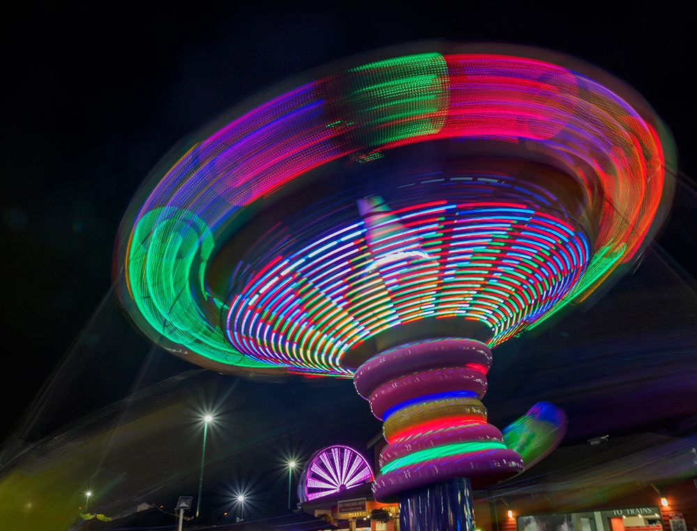 Colorful motion blur of spinning ride at a carnival. art print by Merrill Images for $57.95 CAD