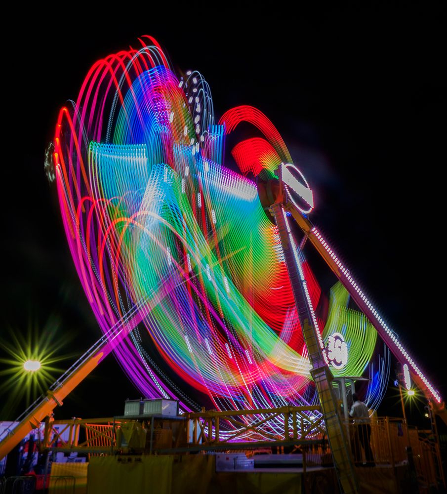 Colorful motion blur of spinning ride at a carnival. art print by Merrill Images for $57.95 CAD