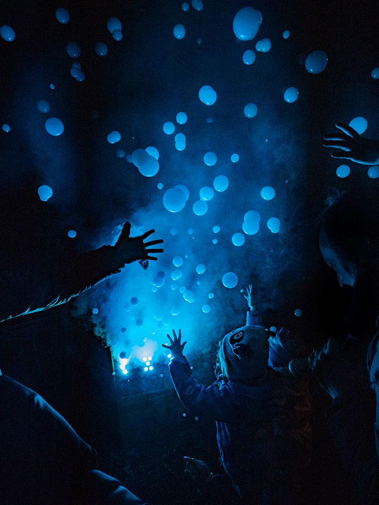 People at a concert reaching out to smoke bubbles. art print by Merrill Images for $57.95 CAD