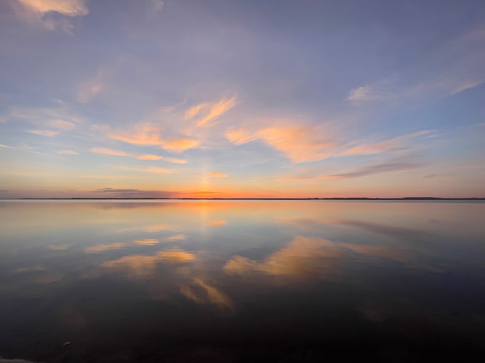 Sunset sky reflected on tranquil water on beach. art print by Merrill Images for $57.95 CAD