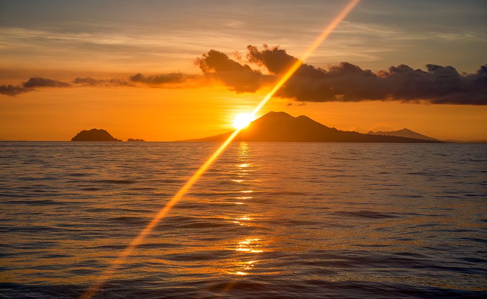 Coral Sea, Papua New Guinea. Landscape view across the ocean of volcanic islands at sunrise. art print by Murray McCallum for $57.95 CAD
