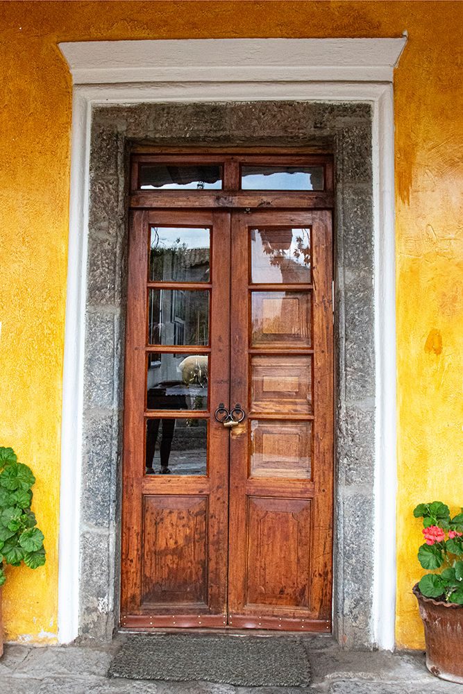 Old wooden doorway with geranium plants at Hacienda San Augustin de Callo in Ecuador. art print by Mallorie Ostrowitz for $57.95 CAD