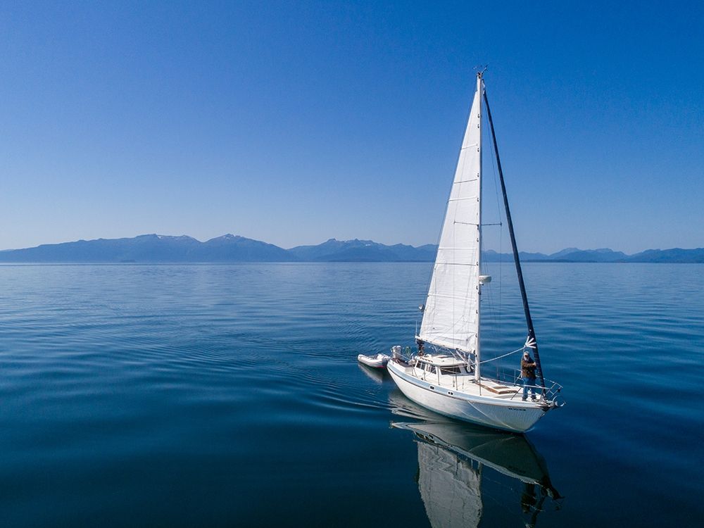 Alaska-Aerial view of Gulf 32 pilothouse boat motoring and sailing in calm waters of Frederick Sound art print by Paul Souders for $57.95 CAD