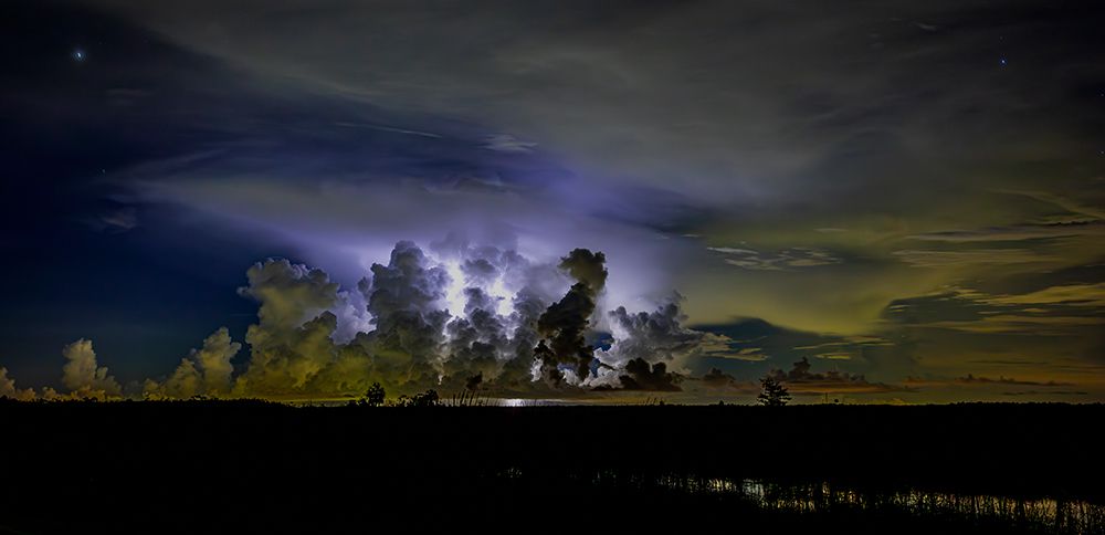 A distant thunder storm and sky draws contrast to the dark Big Cypress prairie. art print by Larry Richardson for $57.95 CAD