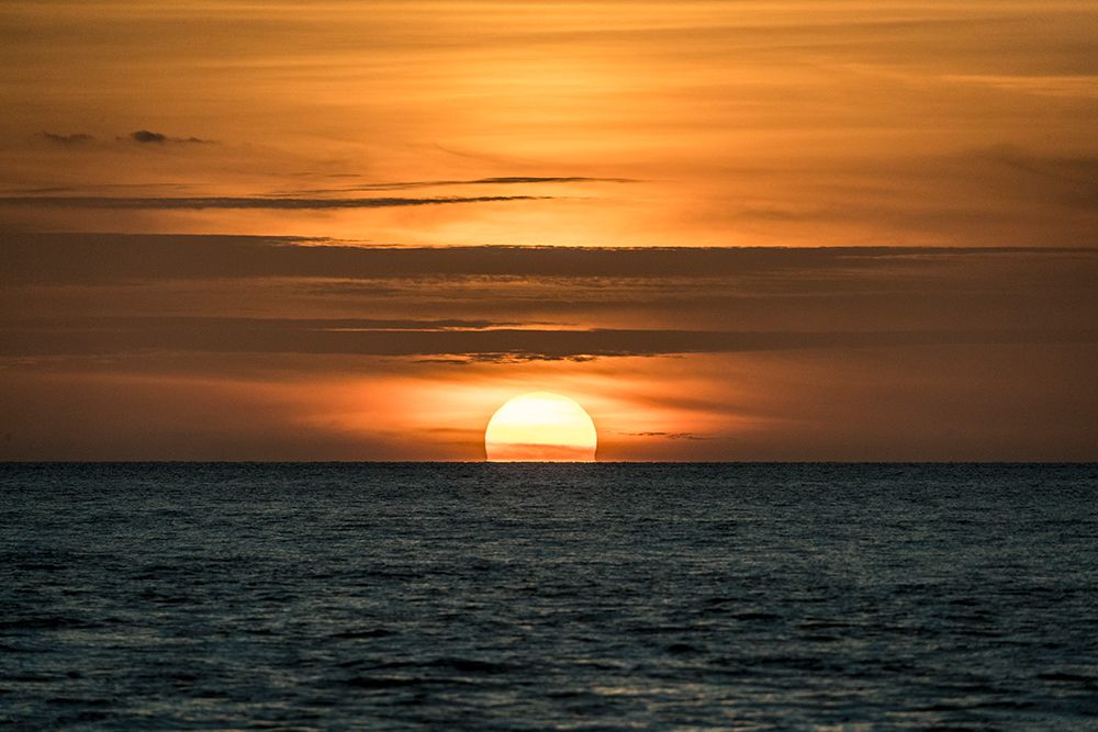 Sun sets amid light clouds in the Gulf of Mexico. art print by Larry Richardson for $57.95 CAD