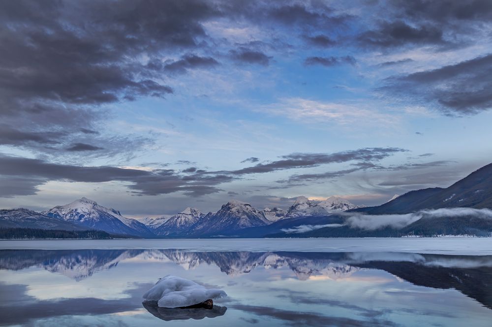 Clouds reflect in opening in the ice on Lake McDonald in Glacier National Park, Montana, USA. art print by Chuck Haney for $57.95 CAD