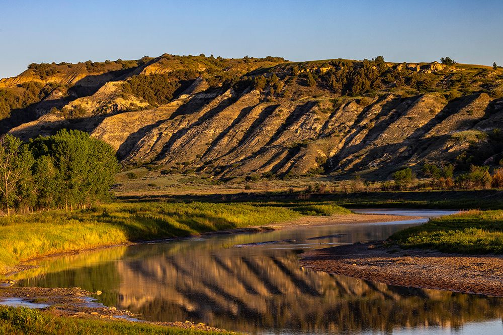 Cliffs reflection in the Little Missouri River at sunrise in Theodore Roosevelt NP, North Dakota. art print by Chuck Haney for $57.95 CAD