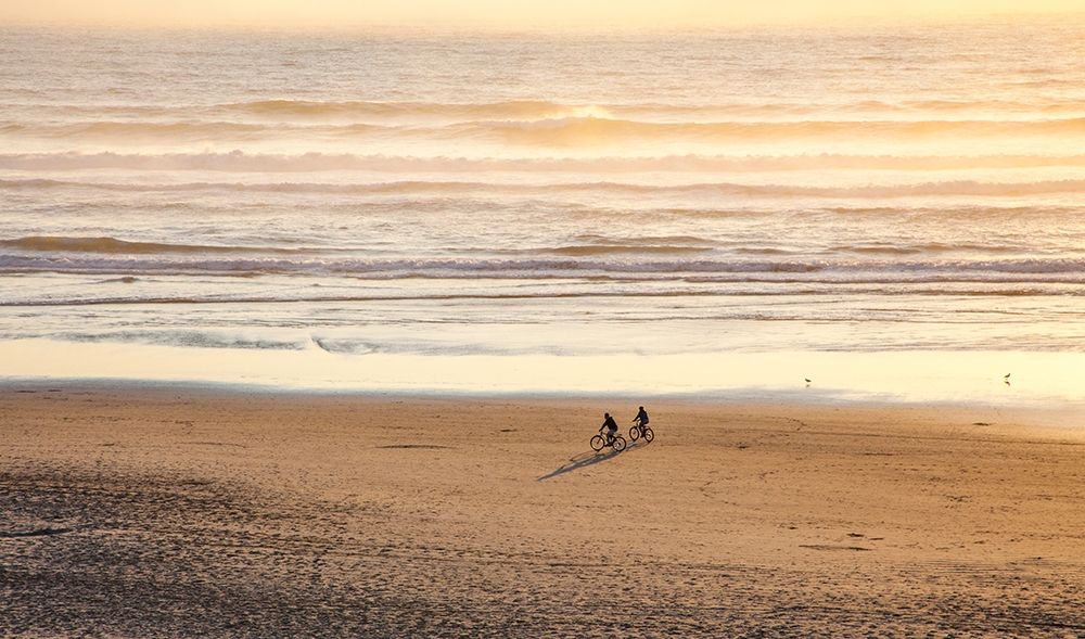 Oregon-Cape Arch with two riding bikes on the beach in the evening light art print by Sylvia Gulin for $57.95 CAD