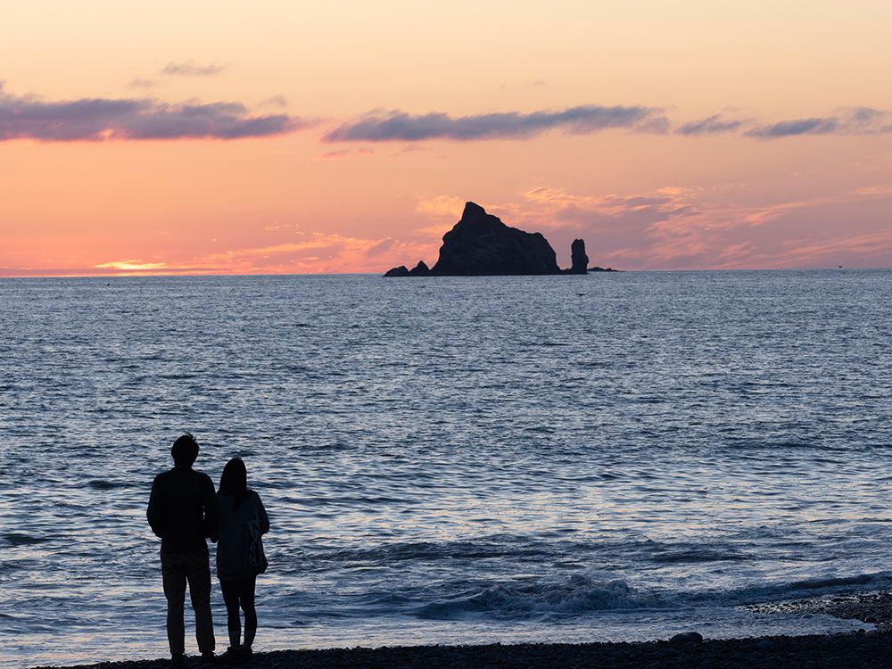 Couple silhouetted at sunset. Rialto Beach, Olympic Peninsula, Washington State. art print by Merrill Images for $57.95 CAD