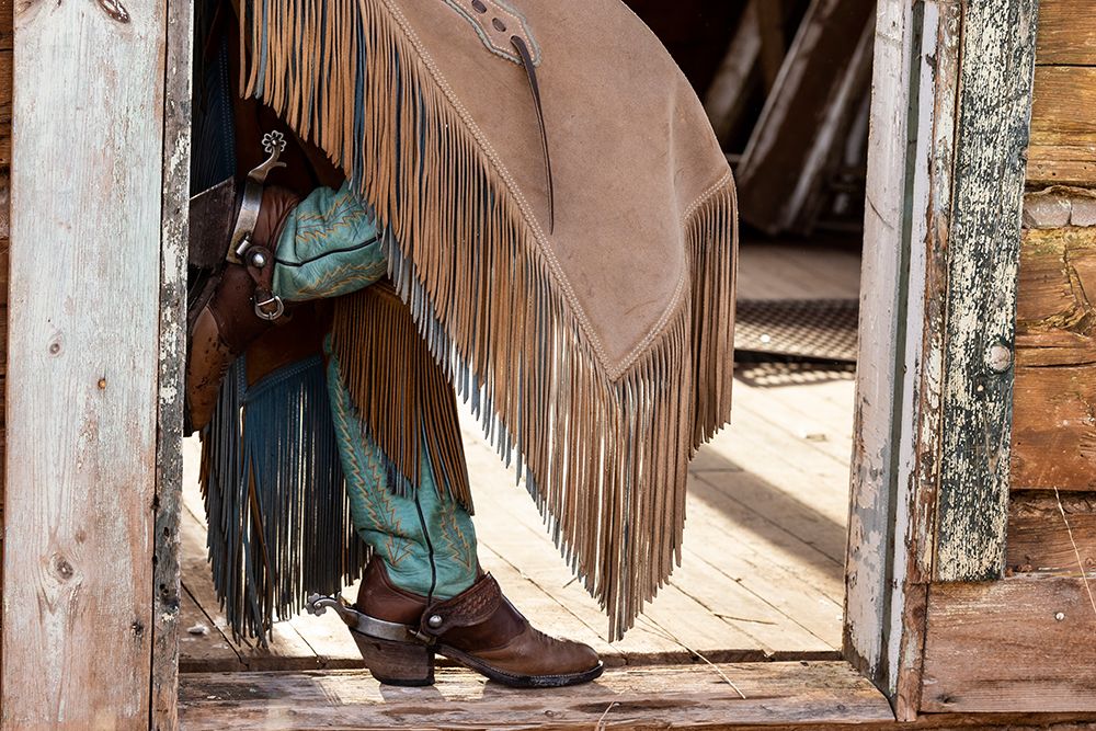 USA- Shell- Wyoming. Hideout Ranch cowgirl standing in doorway with cowboy boots and chaps. art print by Darrell Gulin for $57.95 CAD