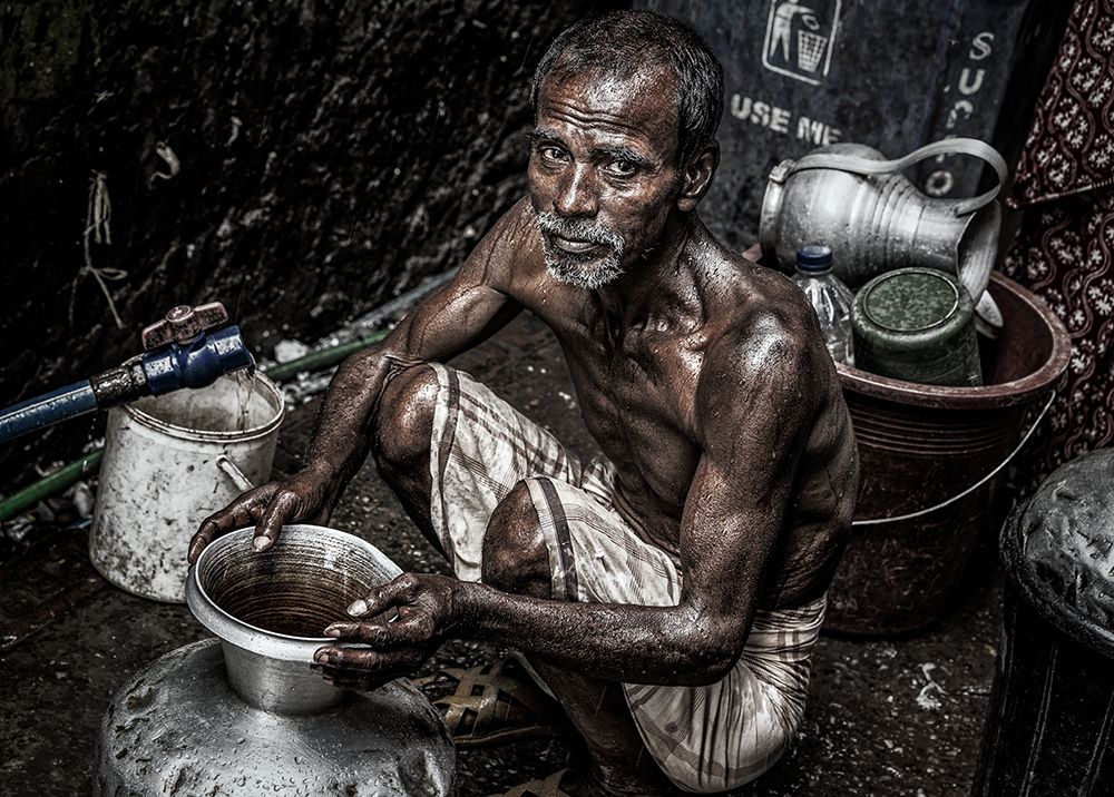 Man Filling A Pitcher With Water In The Streets Of Bangladesh. art print by Joxe Inazio Kuesta for $57.95 CAD