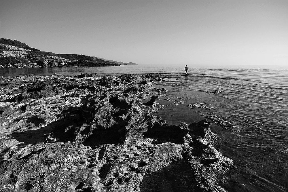 Person facing sea rock black white art print by Archivio for $57.95 CAD
