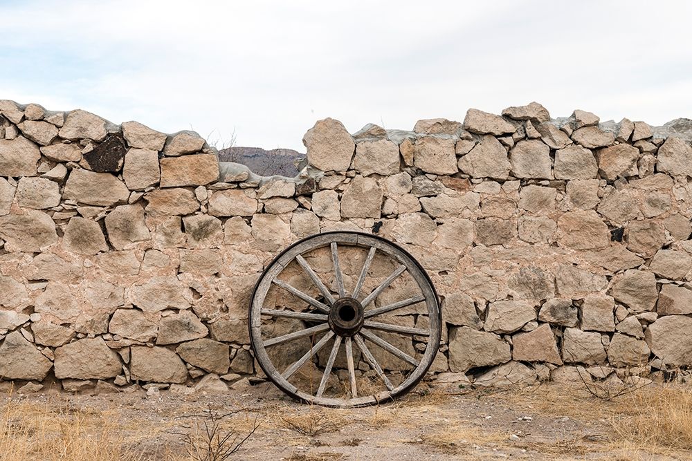 Wagon wheel against a stone fence at Hueco Tanks State Park, northwest of El Paso, TX art print by Carol Highmith for $57.95 CAD