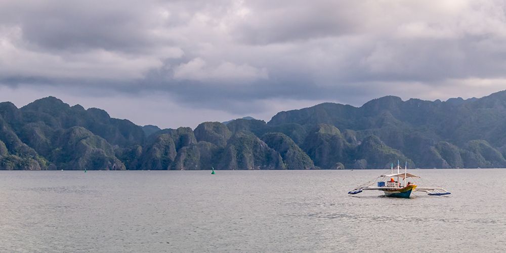 Bangka Boat with Limestone Mountain Range, El Nido, Palawan, Philippines art print by Richard Silver for $57.95 CAD